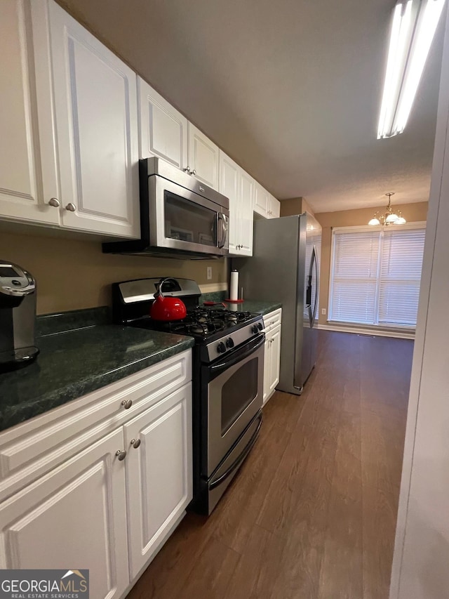 kitchen featuring stainless steel appliances, a chandelier, white cabinetry, and dark wood finished floors