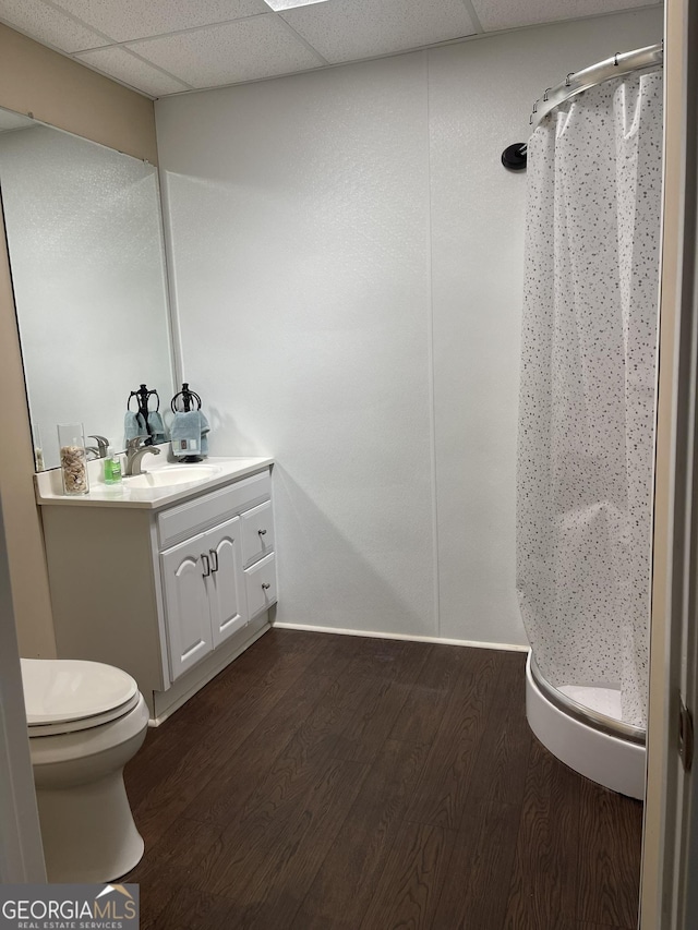 bathroom with a stall shower, vanity, toilet, and wood finished floors