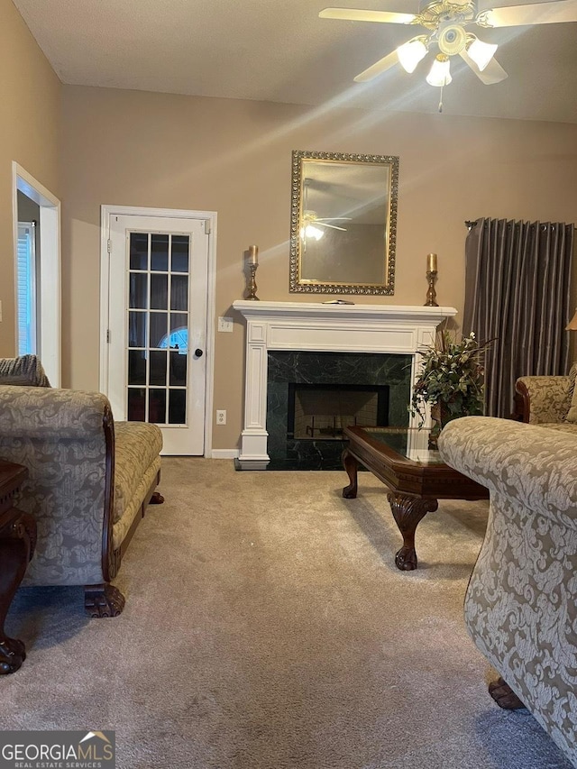 sitting room featuring ceiling fan, a fireplace, and carpet flooring