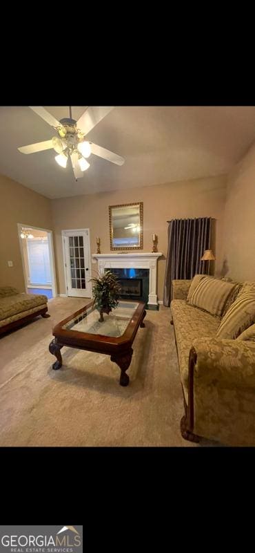 living room with ceiling fan, carpet, and a fireplace