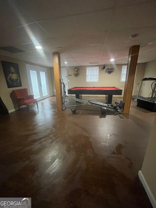 rec room featuring baseboards, a paneled ceiling, and a healthy amount of sunlight