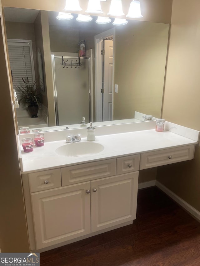 bathroom featuring vanity, baseboards, and wood finished floors