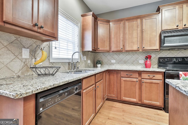 kitchen featuring sink, black appliances, tasteful backsplash, and light hardwood / wood-style flooring