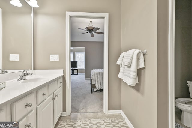 bathroom featuring toilet, ceiling fan, and vanity