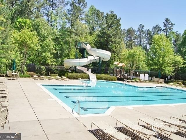 view of swimming pool with a patio and a water slide