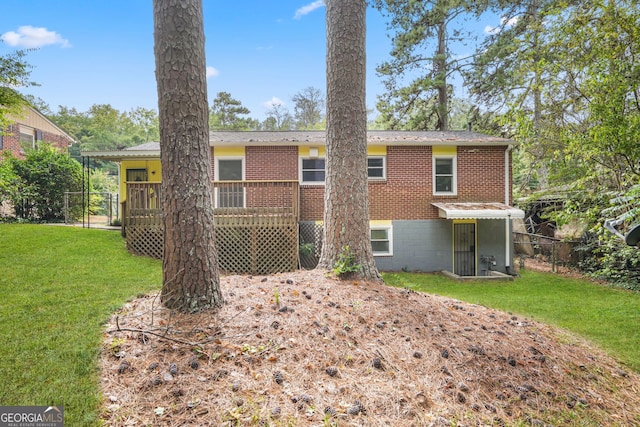 rear view of house with a deck and a lawn