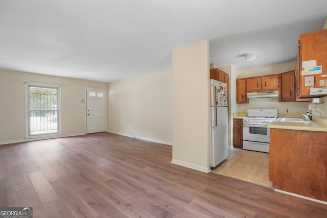 kitchen with sink, white appliances, and light wood-type flooring