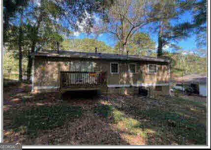 rear view of property with a wooden deck