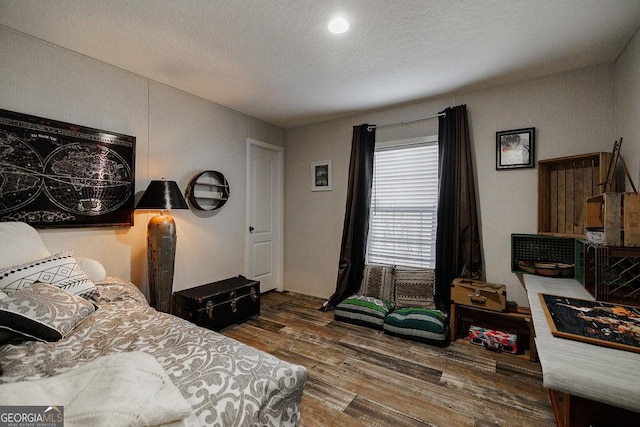 bedroom featuring hardwood / wood-style flooring and a textured ceiling