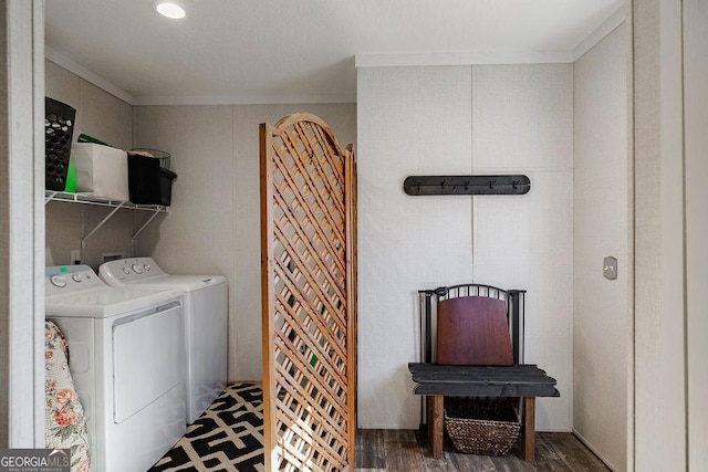 washroom featuring separate washer and dryer, crown molding, and dark hardwood / wood-style flooring