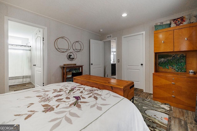 bedroom featuring hardwood / wood-style flooring, ornamental molding, and ensuite bathroom