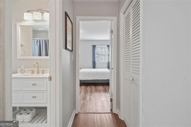 hallway featuring sink and hardwood / wood-style flooring