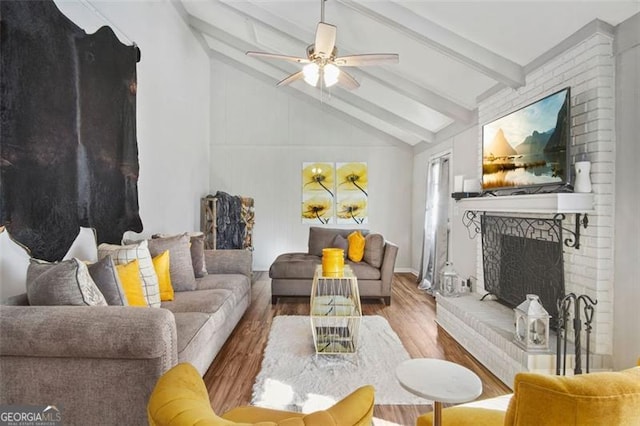 living room featuring wood-type flooring, lofted ceiling with beams, a fireplace, and ceiling fan