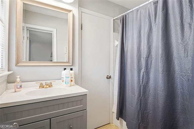 bathroom with walk in shower and vanity