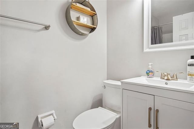 bathroom featuring a shower with curtain, toilet, and vanity