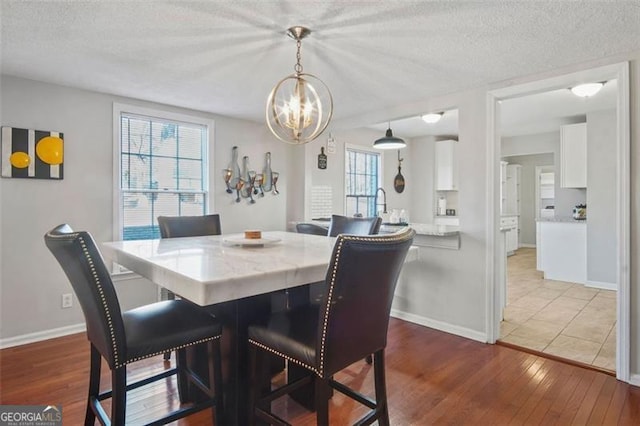 dining area featuring plenty of natural light, wood-type flooring, and a textured ceiling