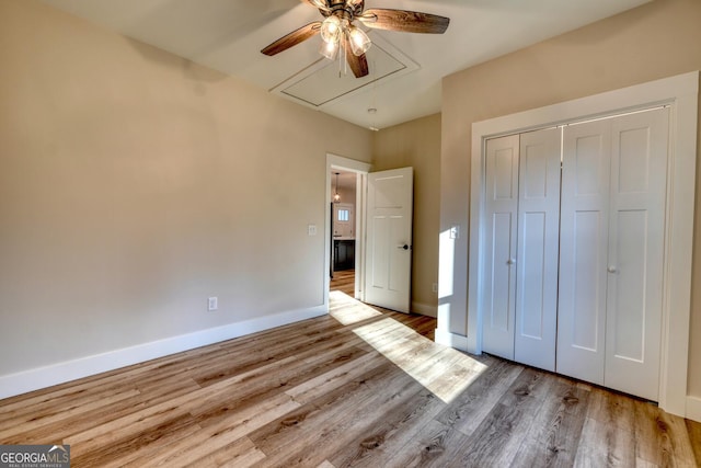 unfurnished bedroom featuring light wood-type flooring, ceiling fan, and a closet