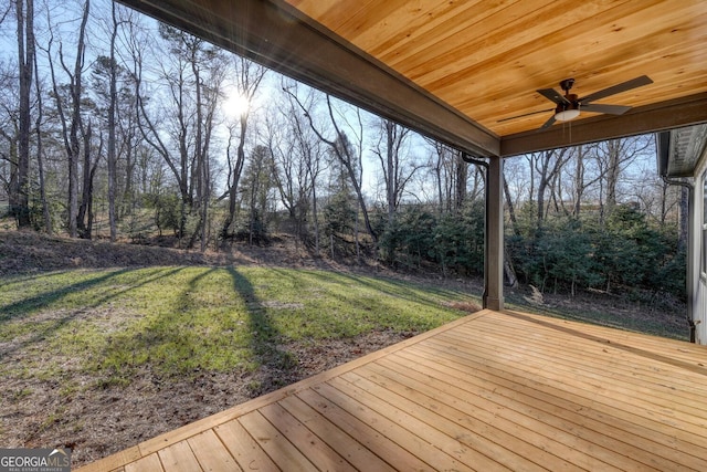 wooden terrace with ceiling fan and a yard