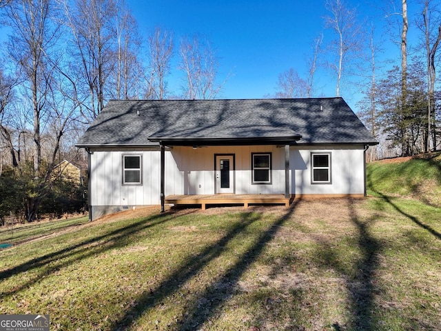 rear view of property featuring covered porch and a yard