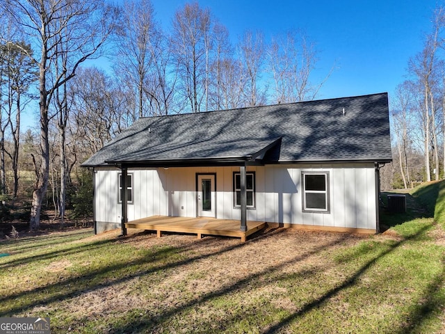 exterior space with a wooden deck, a front yard, and cooling unit