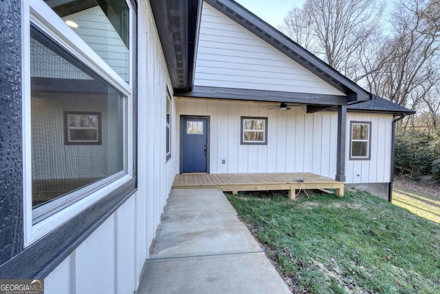 exterior space with ceiling fan, a deck, and a lawn