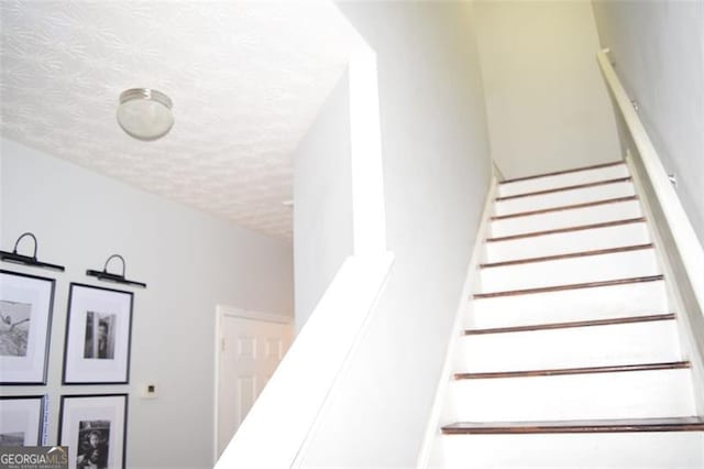 staircase with a textured ceiling