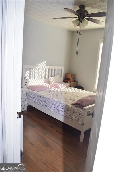 bedroom with ceiling fan and dark hardwood / wood-style flooring