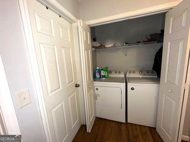 clothes washing area with independent washer and dryer and dark hardwood / wood-style flooring