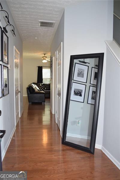 hallway featuring dark wood-type flooring and a textured ceiling