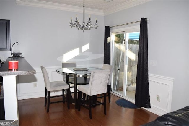 dining space featuring dark wood-type flooring, ornamental molding, and a chandelier