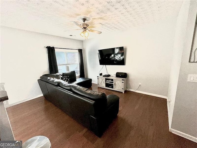 living room featuring ceiling fan, dark hardwood / wood-style floors, and a textured ceiling