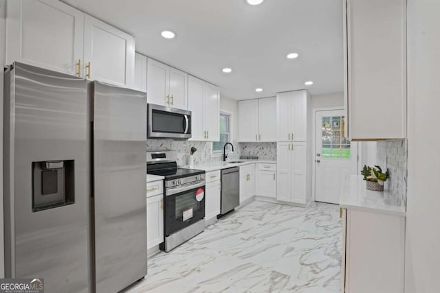 kitchen with white cabinets, stainless steel appliances, decorative backsplash, and sink