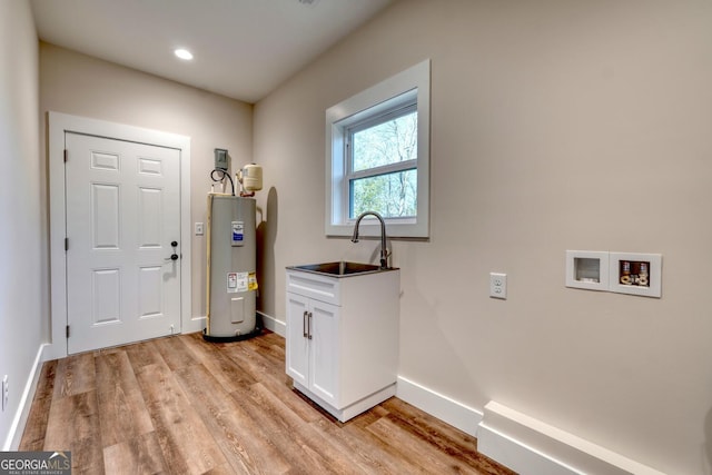 washroom featuring sink, washer hookup, light hardwood / wood-style floors, and electric water heater