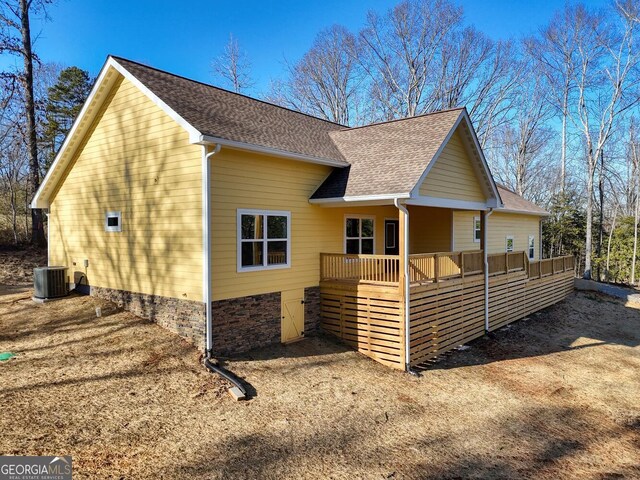 view of side of property featuring a porch and cooling unit