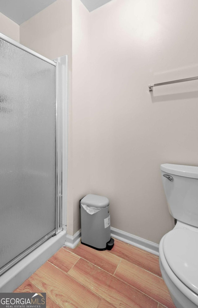 bathroom with toilet and a shower with door