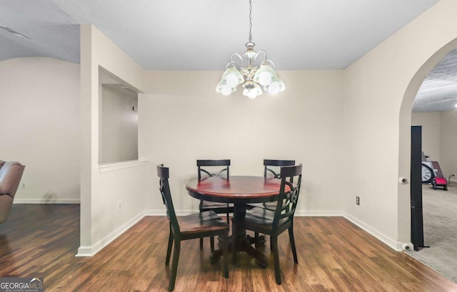 dining room with dark hardwood / wood-style floors and a chandelier