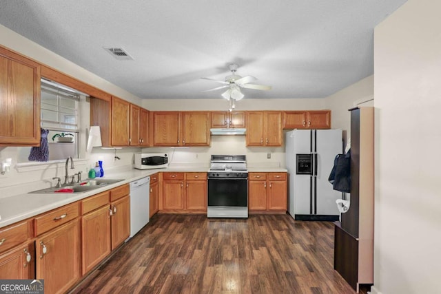 kitchen featuring dark wood-type flooring, sink, a textured ceiling, ceiling fan, and white appliances