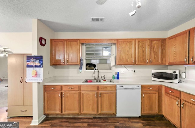 kitchen with sink, dark wood-type flooring, a textured ceiling, and white appliances