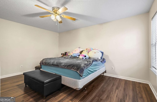 bedroom featuring a textured ceiling, dark wood-type flooring, and ceiling fan