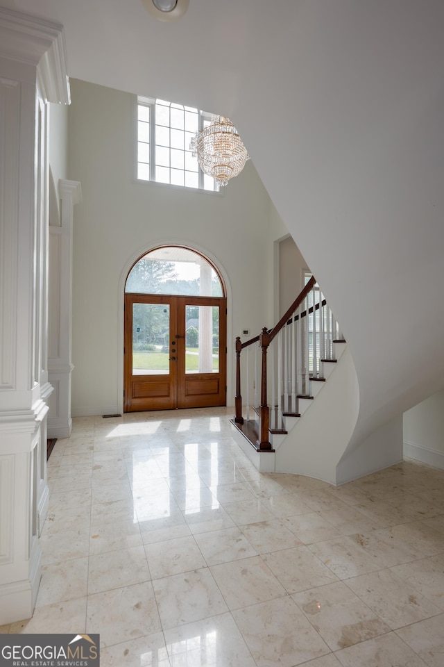 entryway with french doors, a high ceiling, and an inviting chandelier