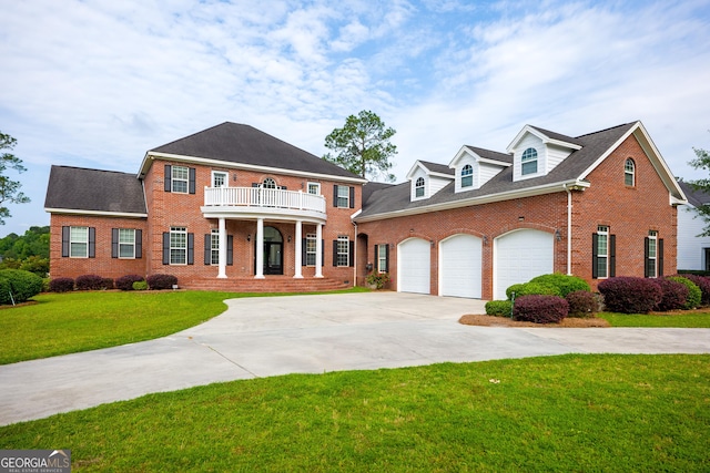 colonial home featuring a balcony, a front lawn, and a garage