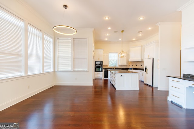 kitchen featuring black appliances, backsplash, white cabinetry, and hanging light fixtures