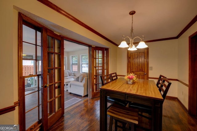 dining space with ornamental molding, dark wood-type flooring, a notable chandelier, and french doors