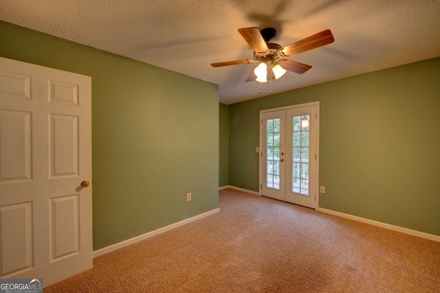 carpeted empty room featuring ceiling fan, french doors, and a textured ceiling