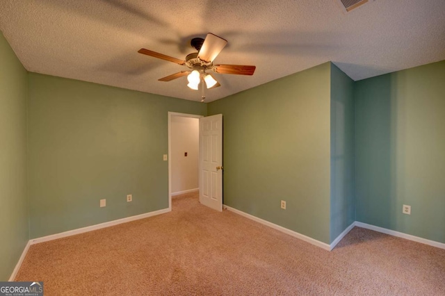 unfurnished room with ceiling fan, a textured ceiling, and light carpet