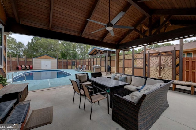 view of patio with a gazebo, a storage unit, a fenced in pool, ceiling fan, and an outdoor hangout area