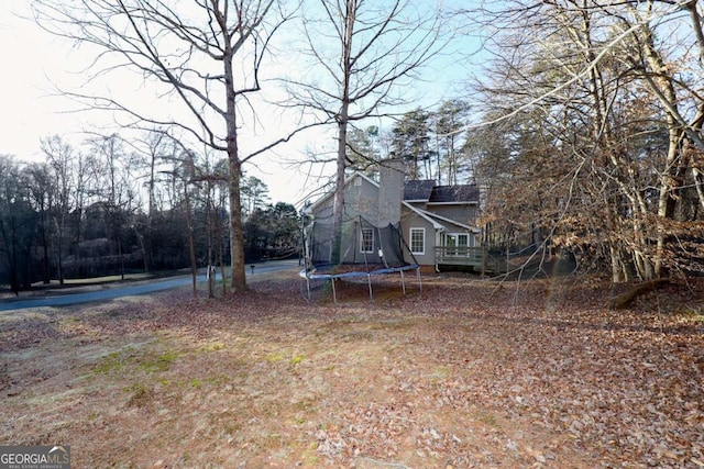 view of yard with a deck and a trampoline