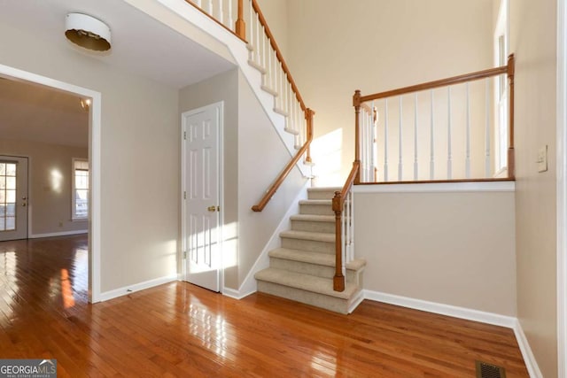 stairs with wood-type flooring, baseboards, and visible vents