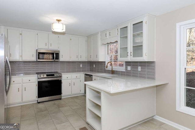 kitchen featuring sink, stainless steel appliances, white cabinetry, and backsplash