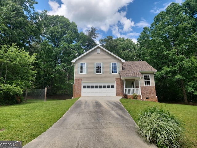 tri-level home with brick siding, a front lawn, and concrete driveway
